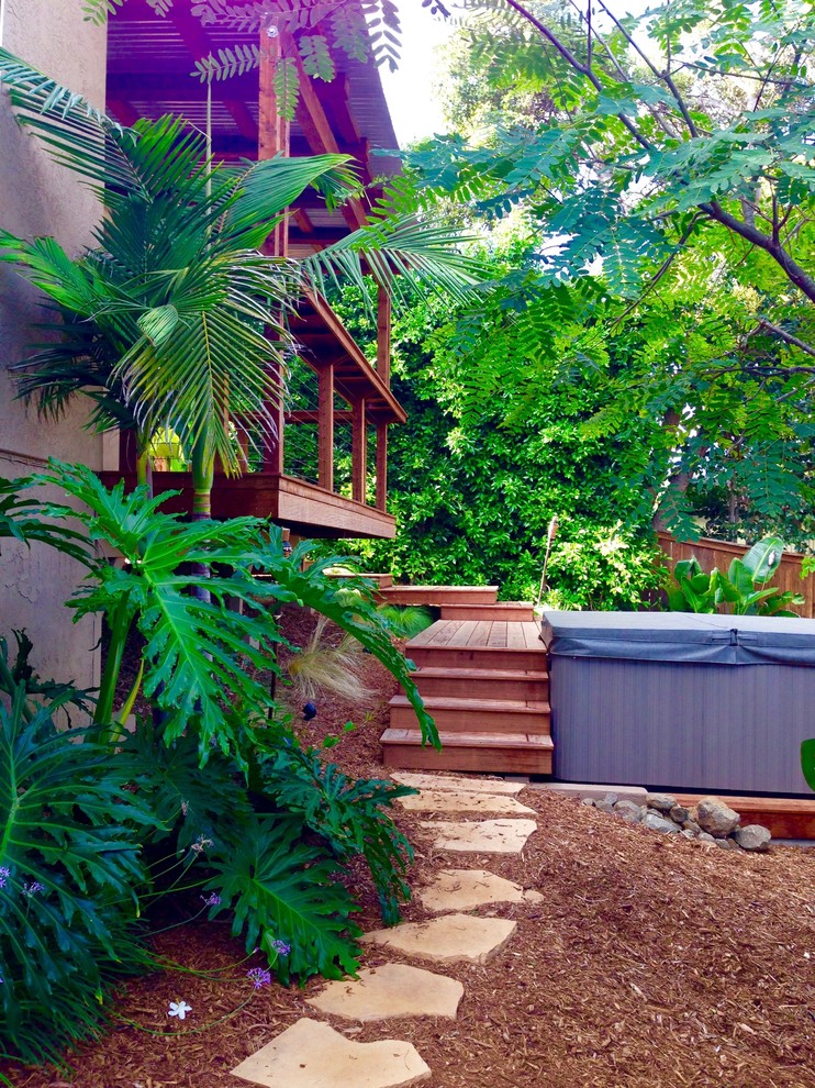 Inspiration for a mid-sized tropical backyard deck in San Diego with an awning.