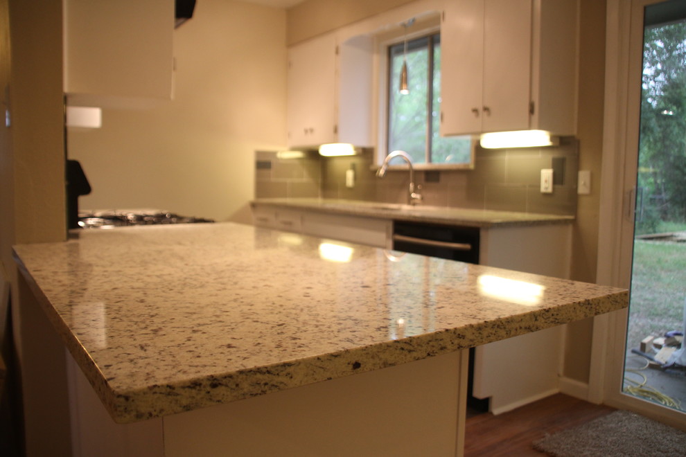 Enclosed kitchen - small transitional u-shaped slate floor enclosed kitchen idea in Austin with an undermount sink, white cabinets, granite countertops, glass tile backsplash, stainless steel appliances, flat-panel cabinets, gray backsplash and no island