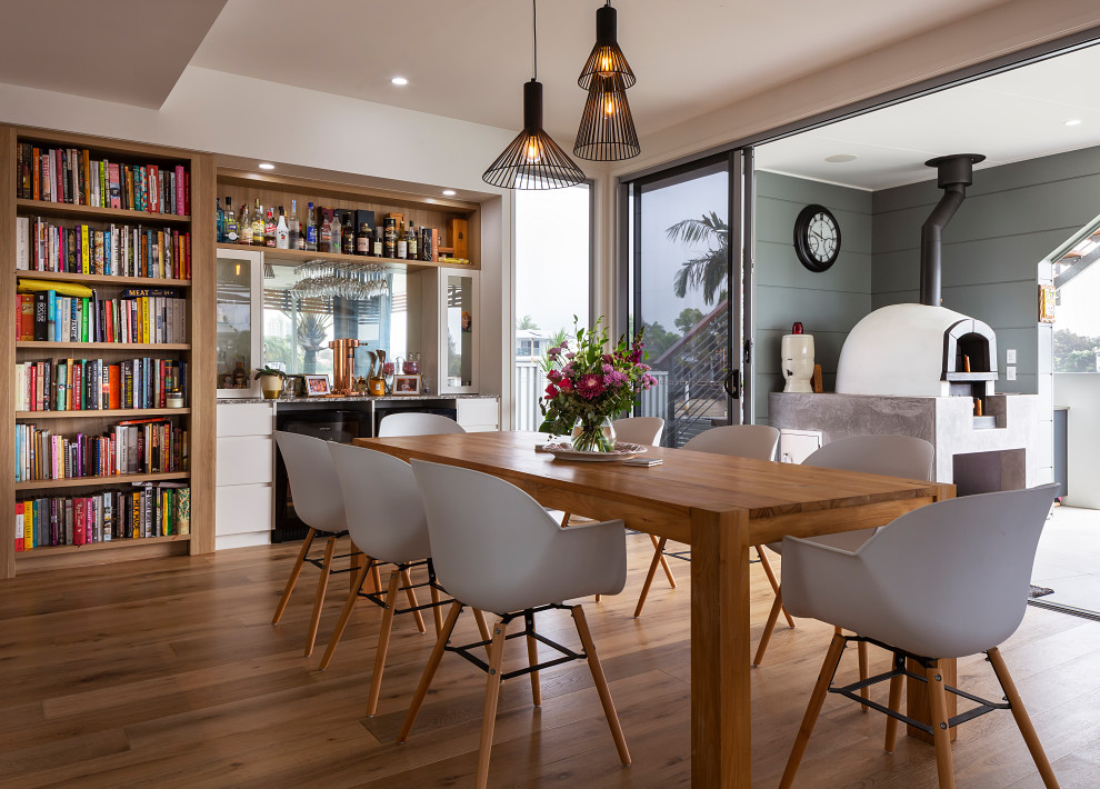 Inspiration for a contemporary dining room in Sunshine Coast with white walls, medium hardwood floors and brown floor.