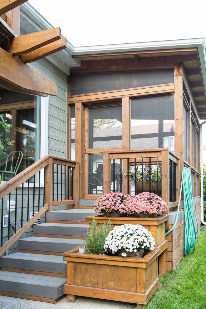 Example of a mid-sized transitional backyard deck design with a roof extension