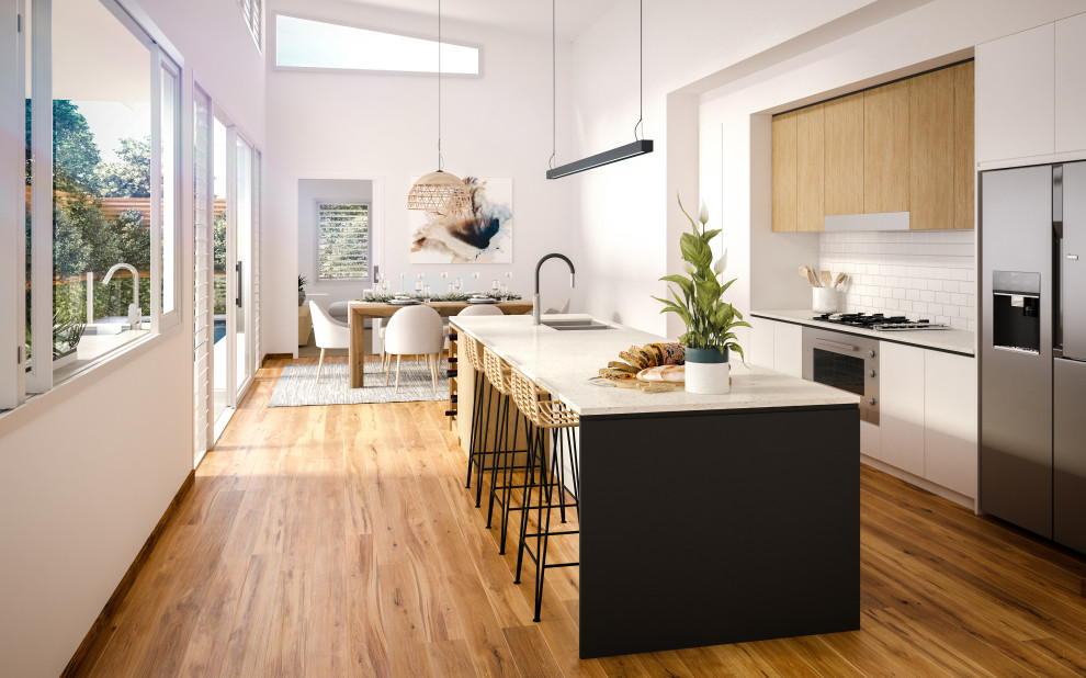 Photo of a mid-sized contemporary galley open plan kitchen in Sydney with an undermount sink, white cabinets, quartz benchtops, white splashback, subway tile splashback, stainless steel appliances, medium hardwood floors, with island and multi-coloured benchtop.