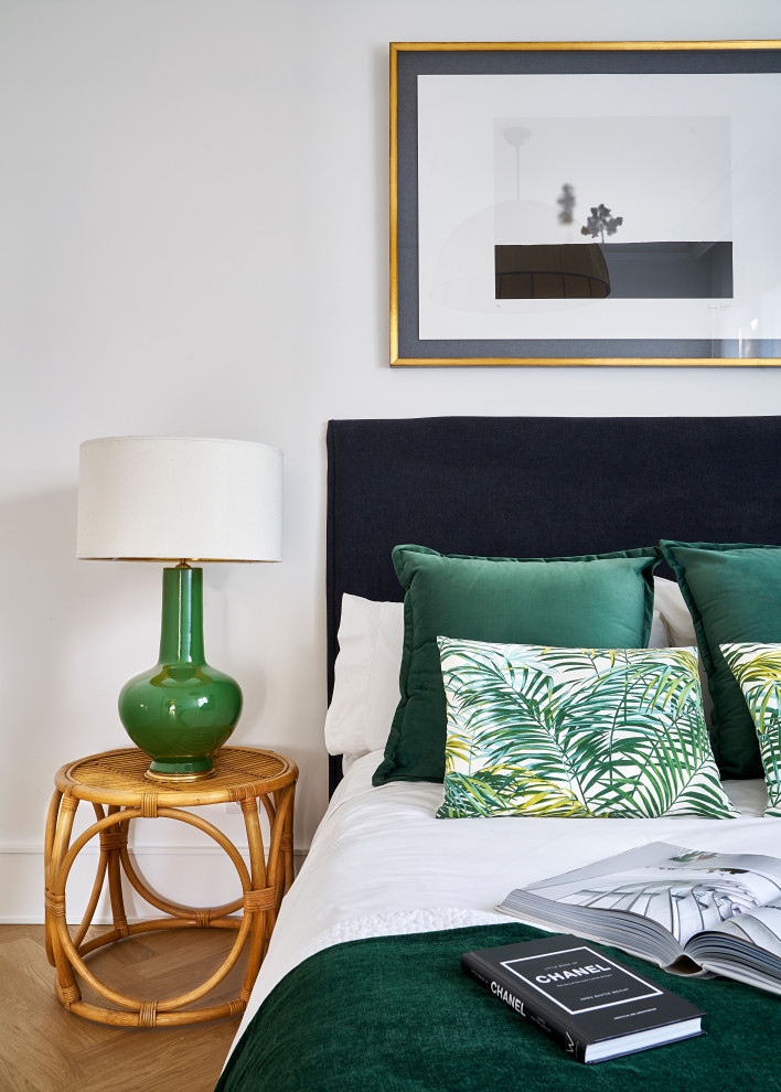 Imagen de habitación de invitados tropical con paredes blancas y suelo de madera clara