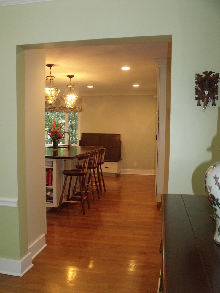 Inspiration for a mid-sized transitional l-shaped light wood floor enclosed kitchen remodel with an undermount sink, shaker cabinets, beige cabinets, wood countertops, beige backsplash, glass tile backsplash, stainless steel appliances and an island
