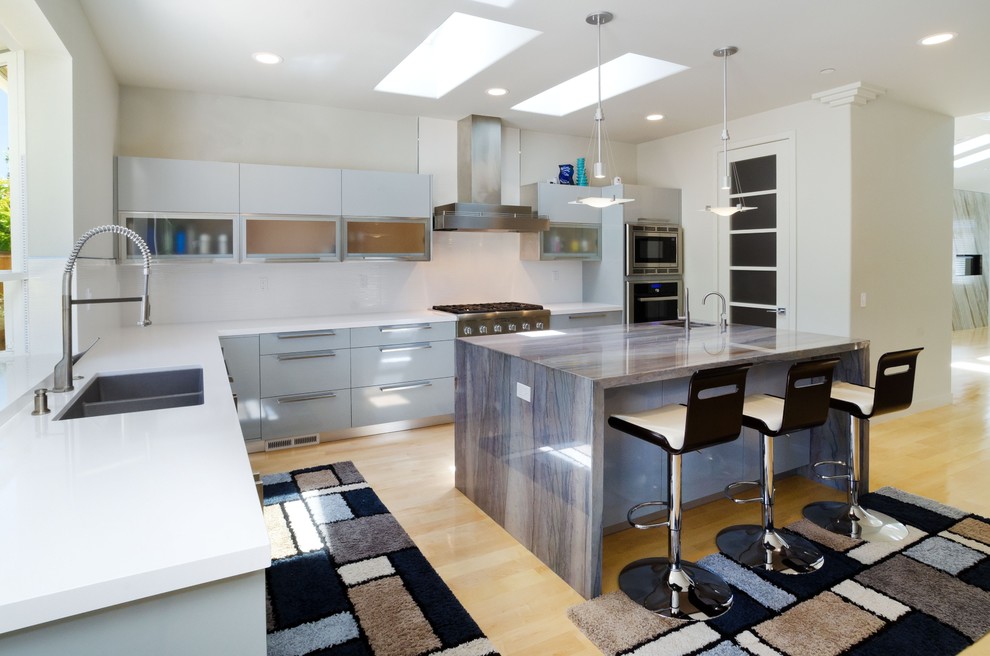 Design ideas for a contemporary l-shaped open plan kitchen in Other with an undermount sink, flat-panel cabinets, grey cabinets, quartz benchtops, white splashback and stainless steel appliances.