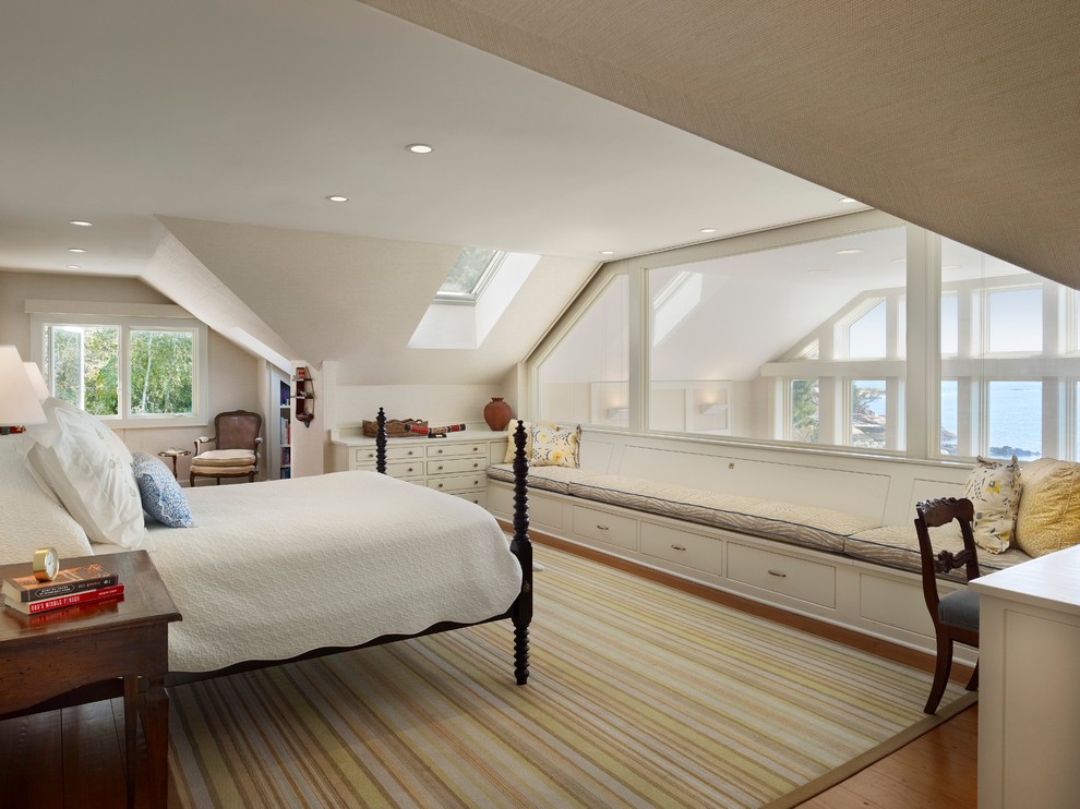 This is an example of a beach style master bedroom in New York with white walls, medium hardwood floors and no fireplace.