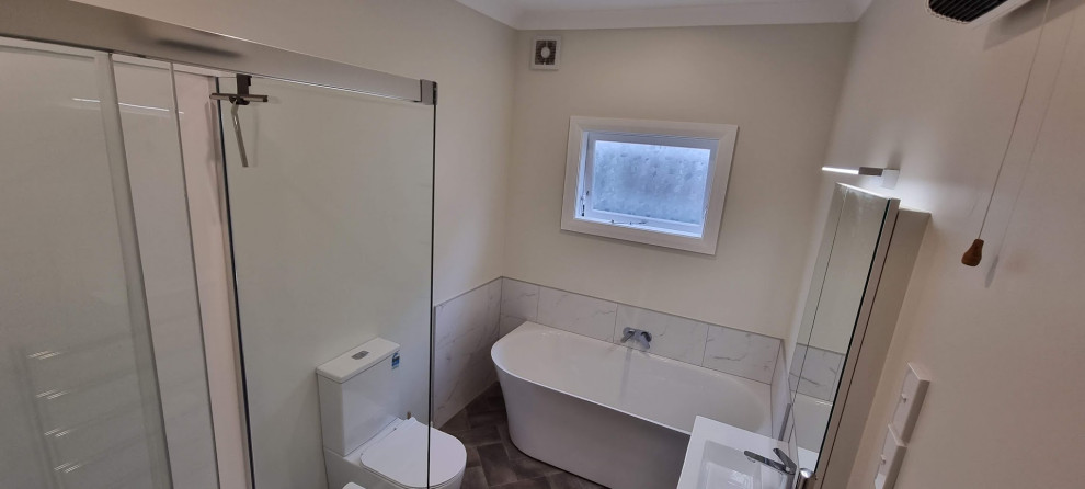 Modern inredning av ett mellanstort en-suite badrum, med vita skåp, ett hörnbadkar, en toalettstol med hel cisternkåpa och vinylgolv