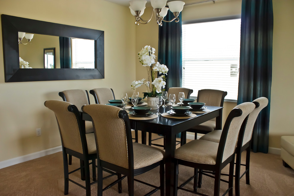 Photo of a small contemporary open plan dining in Orlando with beige walls and carpet.
