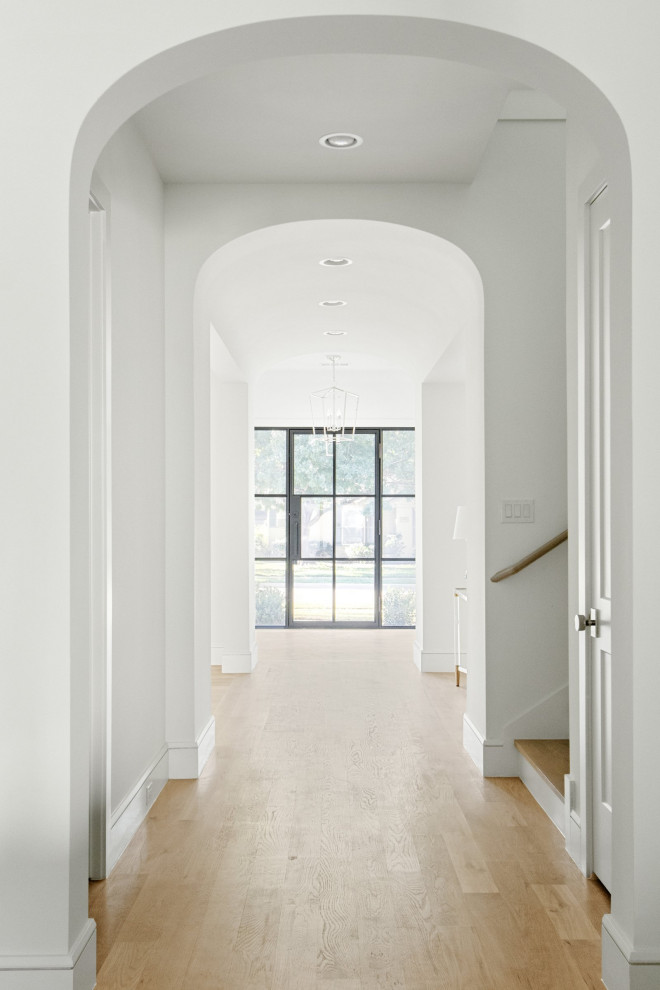 Idee per un ingresso o corridoio stile marino con pareti bianche, parquet chiaro e pavimento beige