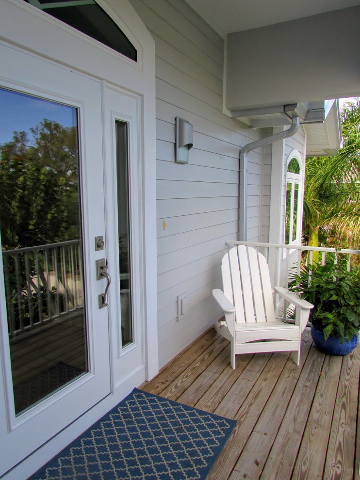Photo of a mid-sized beach style front yard verandah in Miami with decking and a roof extension.