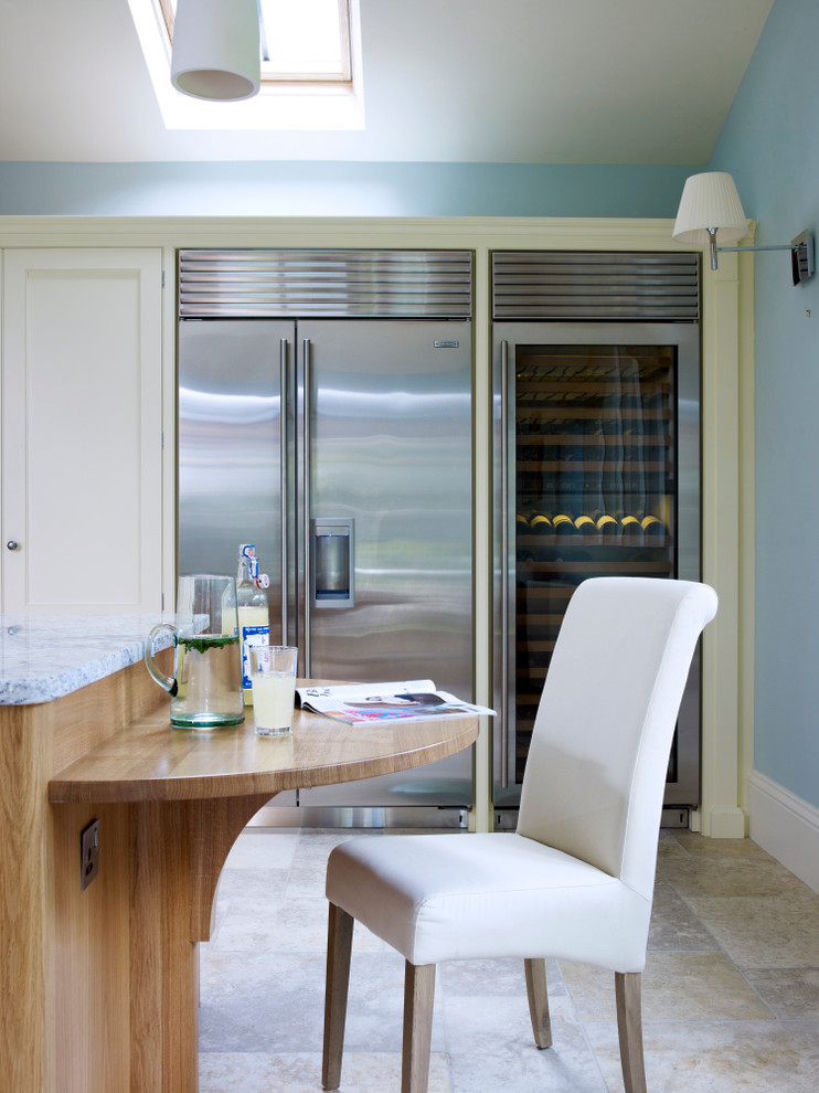 Inspiration for a classic open plan kitchen with a belfast sink, light wood cabinets, stainless steel appliances and an island.