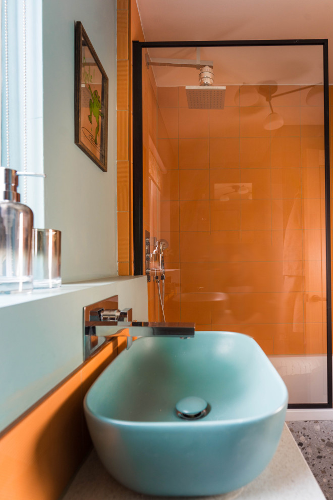 Идея дизайна: маленькая детская ванная комната с стеклянными фасадами, темными деревянными фасадами, накладной ванной, душем над ванной, унитазом-моноблоком, оранжевой плиткой, керамической плиткой, разноцветными стенами, полом из терраццо, подвесной раковиной, столешницей из ламината, серым полом, серой столешницей, нишей, тумбой под одну раковину и встроенной тумбой для на участке и в саду