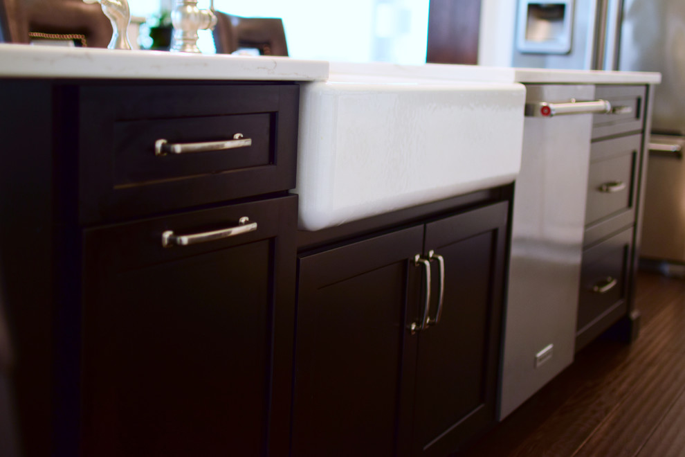 Inspiration for a large transitional l-shaped medium tone wood floor and brown floor eat-in kitchen remodel with a farmhouse sink, shaker cabinets, white cabinets, quartz countertops, white backsplash, marble backsplash, stainless steel appliances and two islands