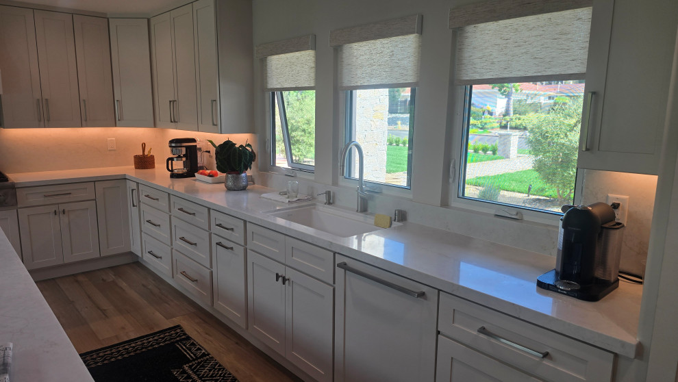 Open concept kitchen - mid-sized l-shaped open concept kitchen idea in Orange County with shaker cabinets, white cabinets, quartz countertops, white backsplash, quartz backsplash, an island and white countertops