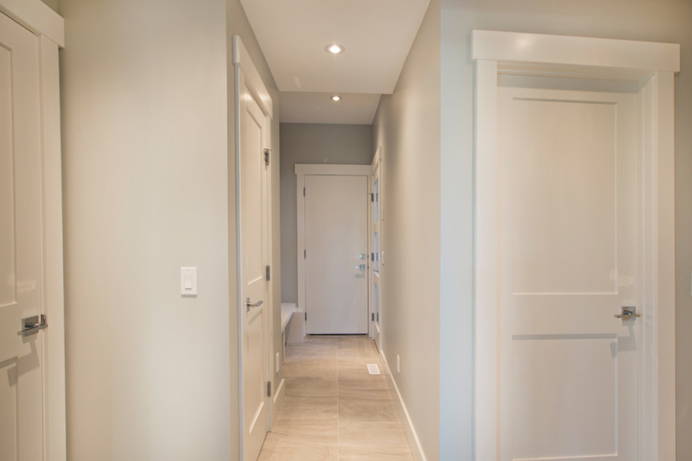 Inspiration for a mid-sized transitional limestone floor hallway remodel in Calgary with white walls