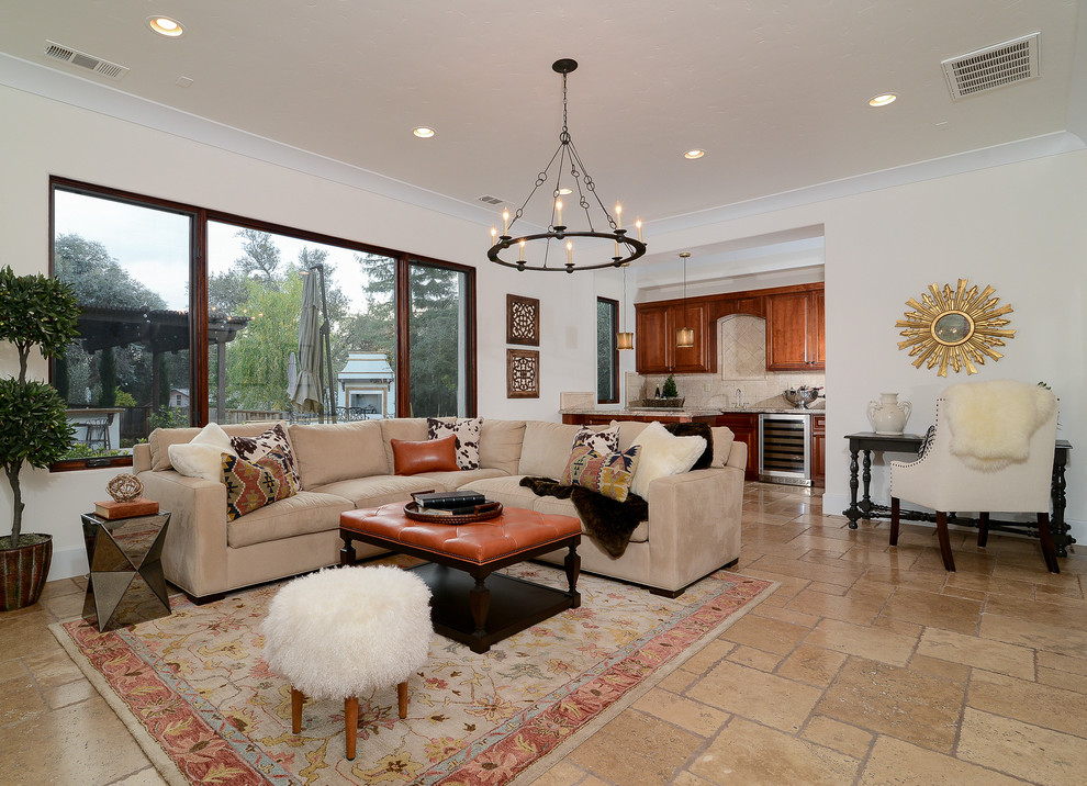 Design ideas for a large mediterranean open concept family room in Sacramento with white walls and travertine floors.