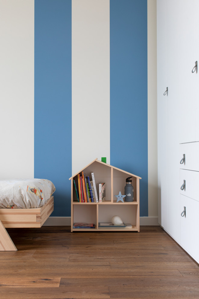 Immagine di una cameretta per bambini da 4 a 10 anni moderna di medie dimensioni con pareti bianche, parquet scuro e pavimento marrone