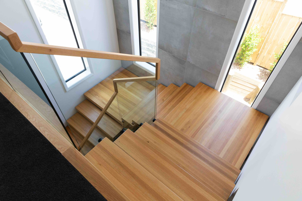 Foto de escalera suspendida moderna de tamaño medio sin contrahuella con escalones de madera y barandilla de madera