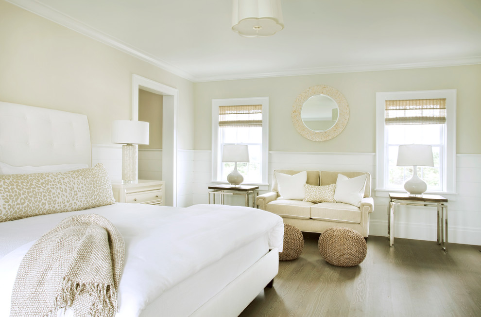 This is an example of a beach style master bedroom in Boston with beige walls and medium hardwood floors.