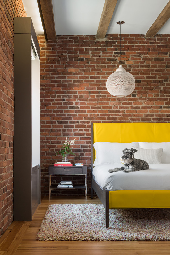 Design ideas for an industrial master bedroom in Boston with red walls and light hardwood floors.