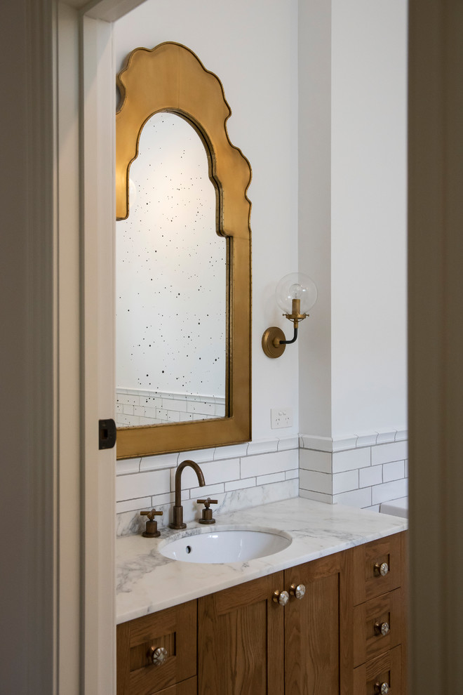 Photo of a large mediterranean master bathroom in Melbourne with furniture-like cabinets, medium wood cabinets, a claw-foot tub, a corner shower, a one-piece toilet, white tile, ceramic tile, white walls, cement tiles, an undermount sink, marble benchtops, yellow floor, an open shower, white benchtops, a single vanity and a floating vanity.