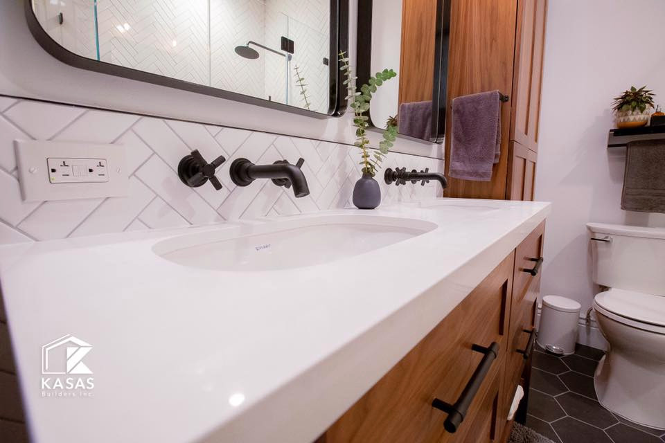 This is an example of a small midcentury ensuite bathroom in San Francisco with shaker cabinets, light wood cabinets, a two-piece toilet, white tiles, ceramic tiles, white walls, ceramic flooring, a submerged sink, engineered stone worktops, black floors, a hinged door, white worktops, a shower bench, double sinks and a built in vanity unit.