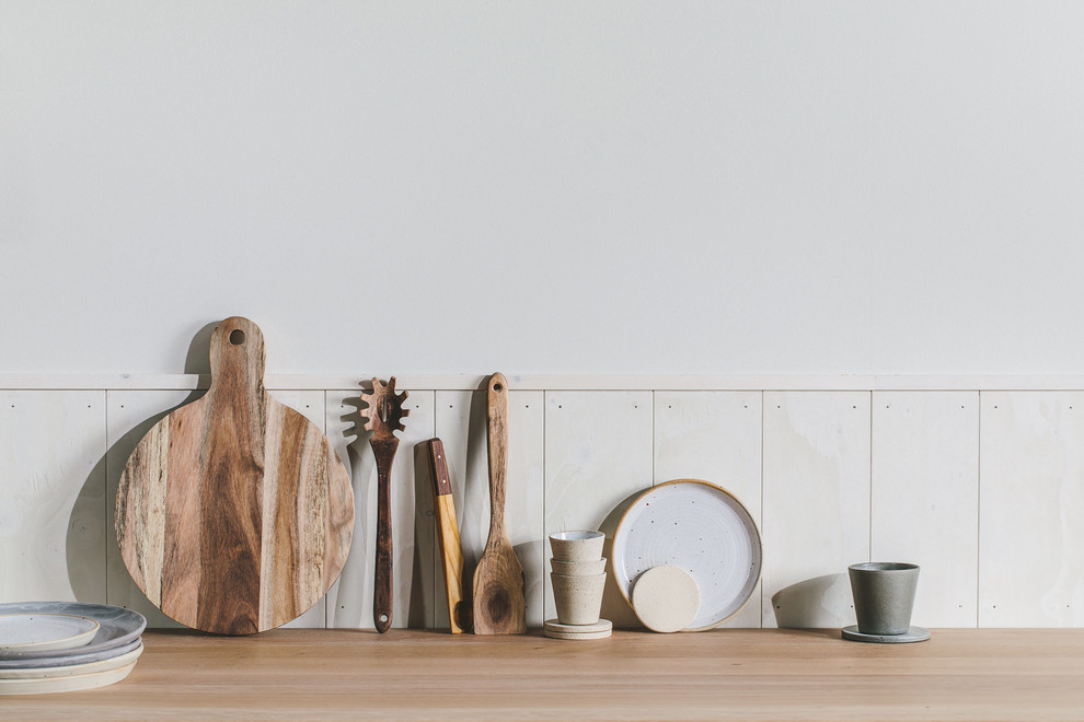 Photo of a small scandi single-wall open plan kitchen with a single-bowl sink, flat-panel cabinets, grey cabinets, wood worktops, white splashback, wood splashback, integrated appliances, painted wood flooring, no island, black floors and brown worktops.