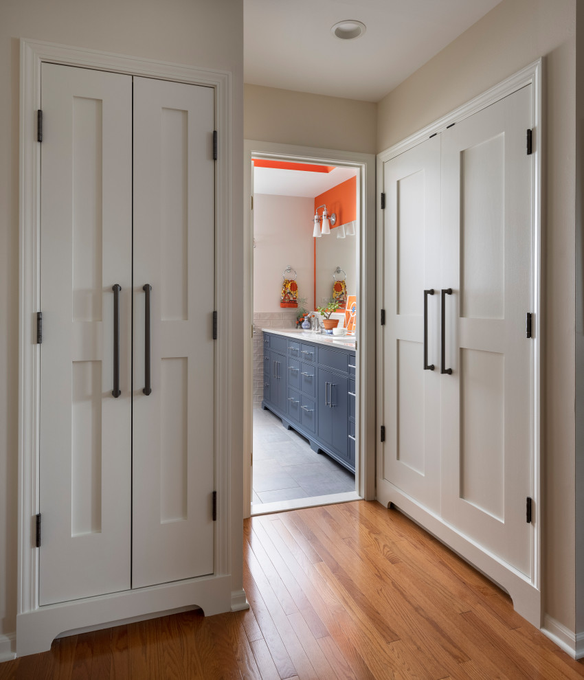Esempio di una stanza da bagno eclettica di medie dimensioni con ante blu, piastrelle grigie, pareti arancioni, pavimento grigio, top bianco e due lavabi