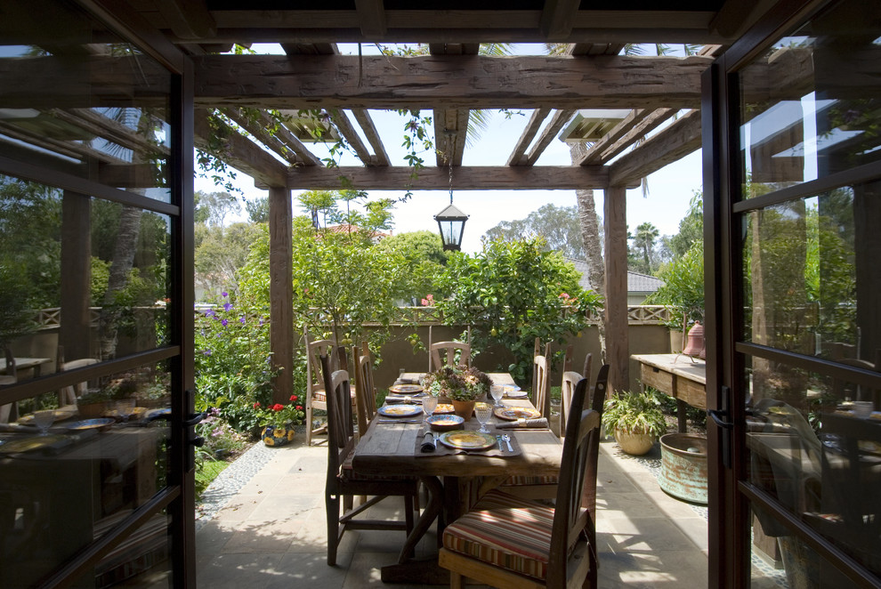 Example of a mid-sized mountain style backyard concrete paver patio design in San Diego with a pergola
