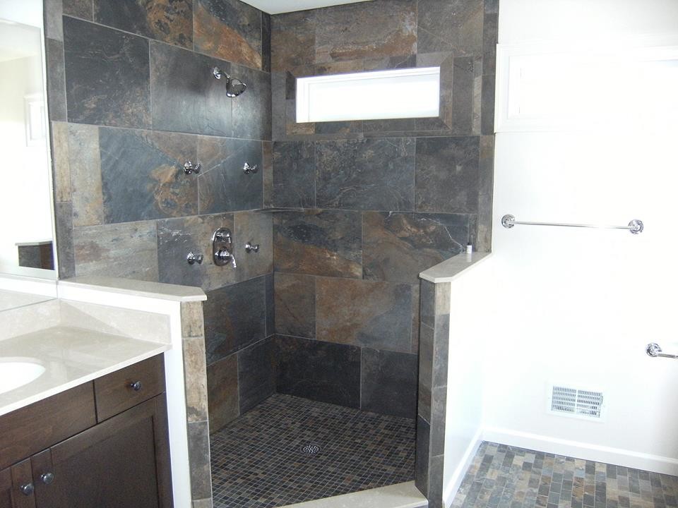 Inspiration for a large transitional master multicolored tile and stone tile slate floor alcove shower remodel in New York with recessed-panel cabinets, dark wood cabinets, a two-piece toilet, white walls, an undermount sink and quartz countertops
