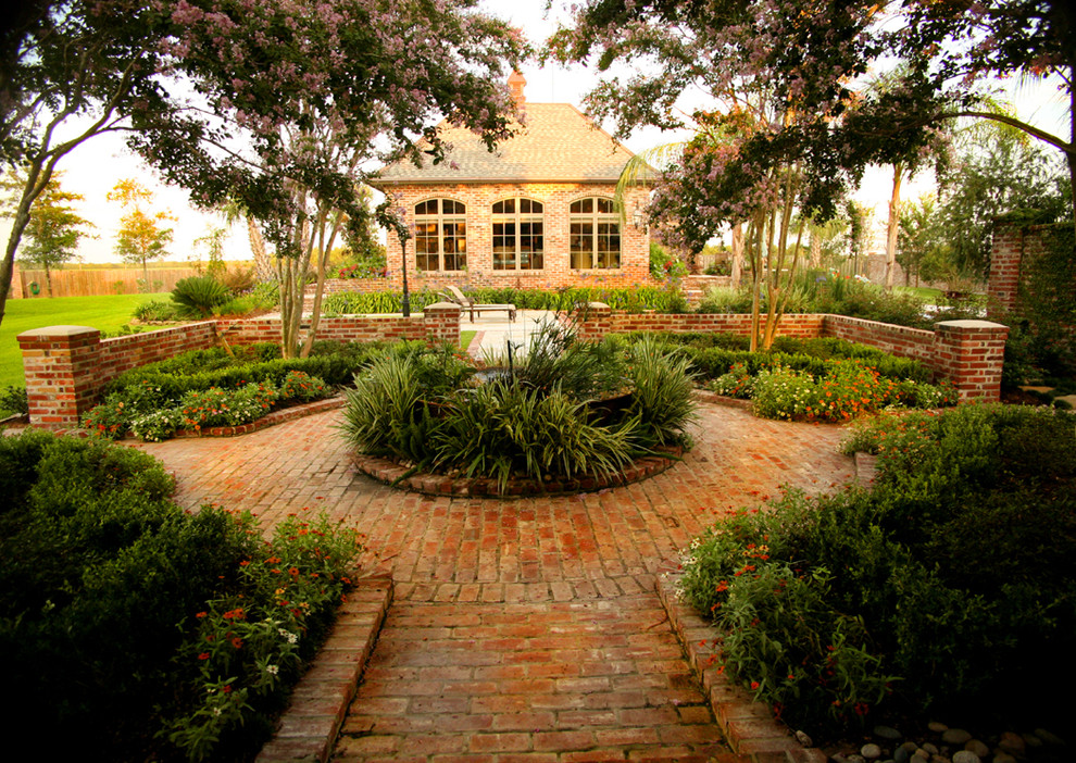 This is an example of a traditional patio in New Orleans with brick pavers and no cover.