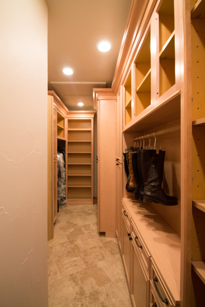 Inspiration for a large traditional gender-neutral walk-in wardrobe in Denver with raised-panel cabinets, light wood cabinets, travertine floors and beige floor.