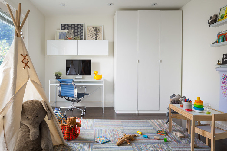 Photo of a mid-sized midcentury gender-neutral kids' room in San Francisco with white walls and dark hardwood floors.