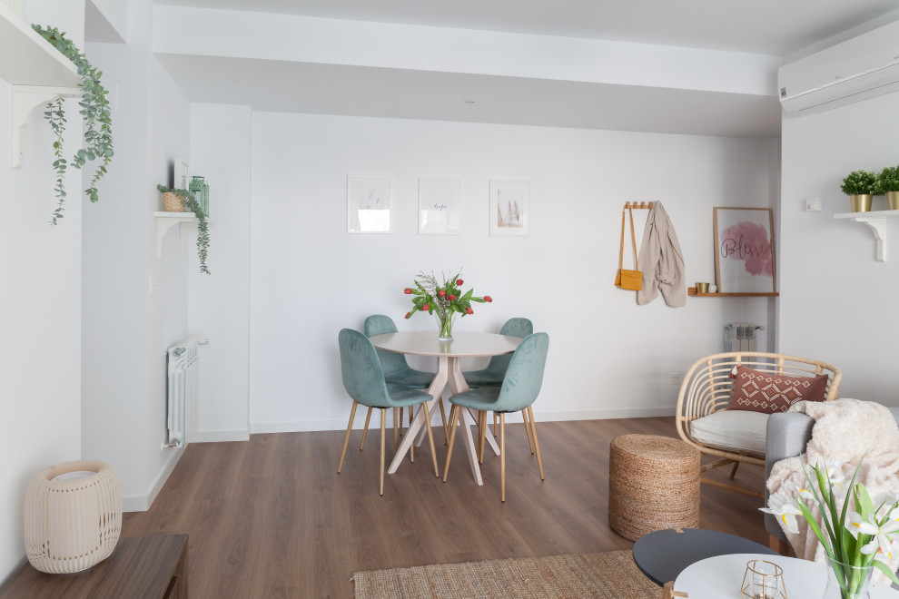 Photo of a medium sized scandinavian open plan dining room in Madrid with white walls, medium hardwood flooring and brown floors.
