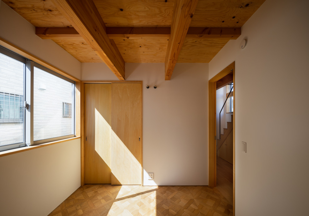 Cette photo montre une chambre d'enfant moderne de taille moyenne avec un mur blanc, un sol en bois brun, un sol marron et poutres apparentes.