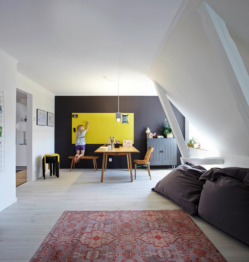 This is an example of an expansive scandinavian kids' room in Bremen with white walls and light hardwood floors.