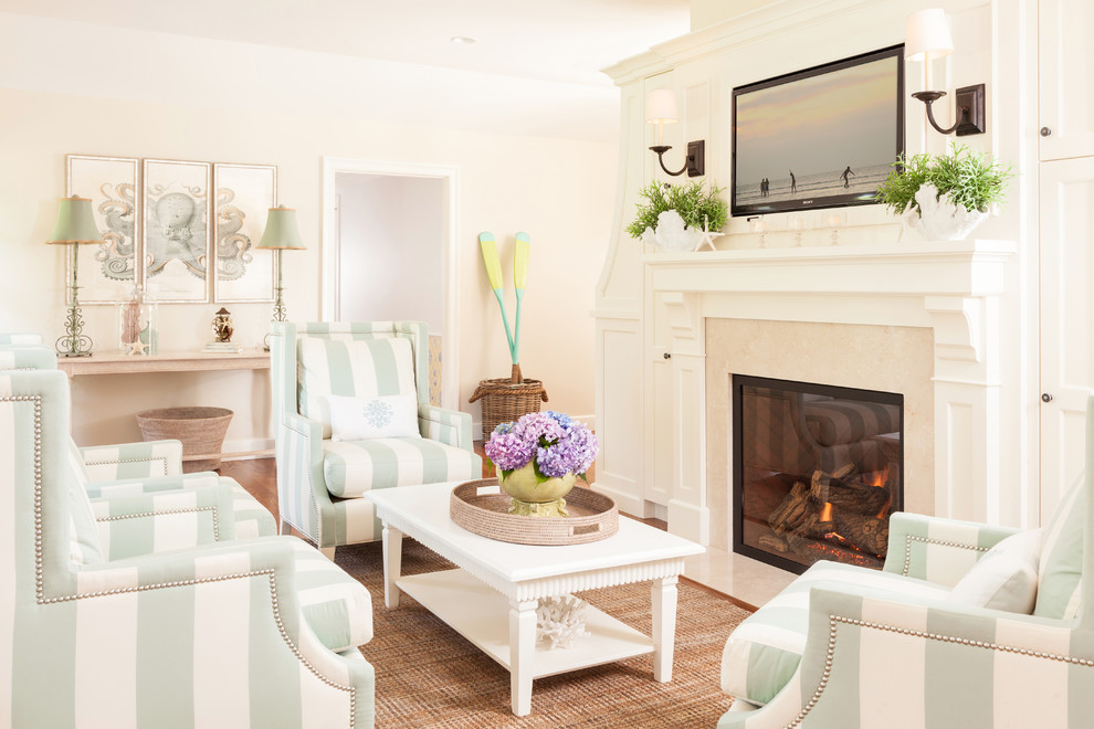 Inspiration for a mid-sized beach style formal enclosed living room in Boston with beige walls, medium hardwood floors, a standard fireplace and a wall-mounted tv.