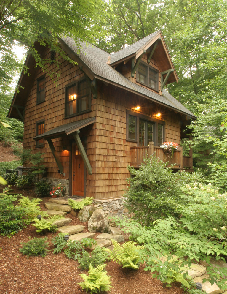 This is an example of a small country two-storey brown exterior in Other with wood siding and a gable roof.