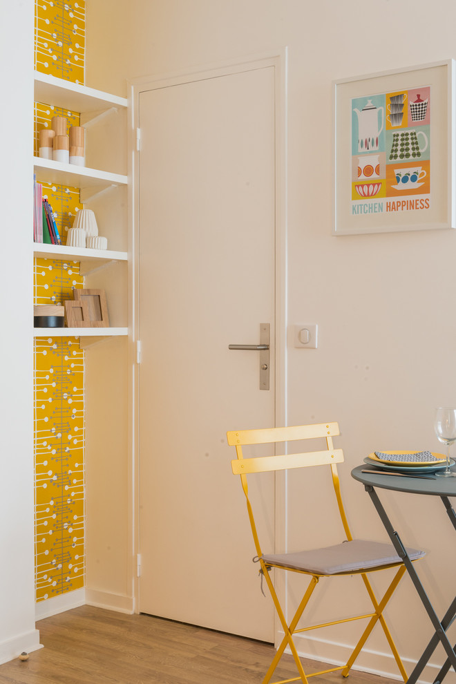 Photo of a small scandinavian dining room in Paris with yellow walls and medium hardwood floors.