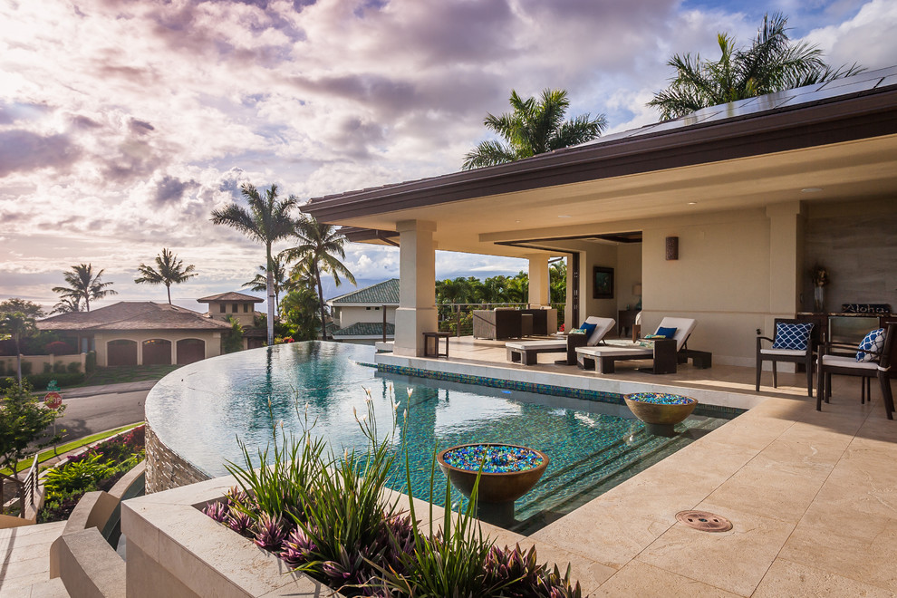 Design ideas for a tropical custom-shaped infinity pool in Hawaii with tile.