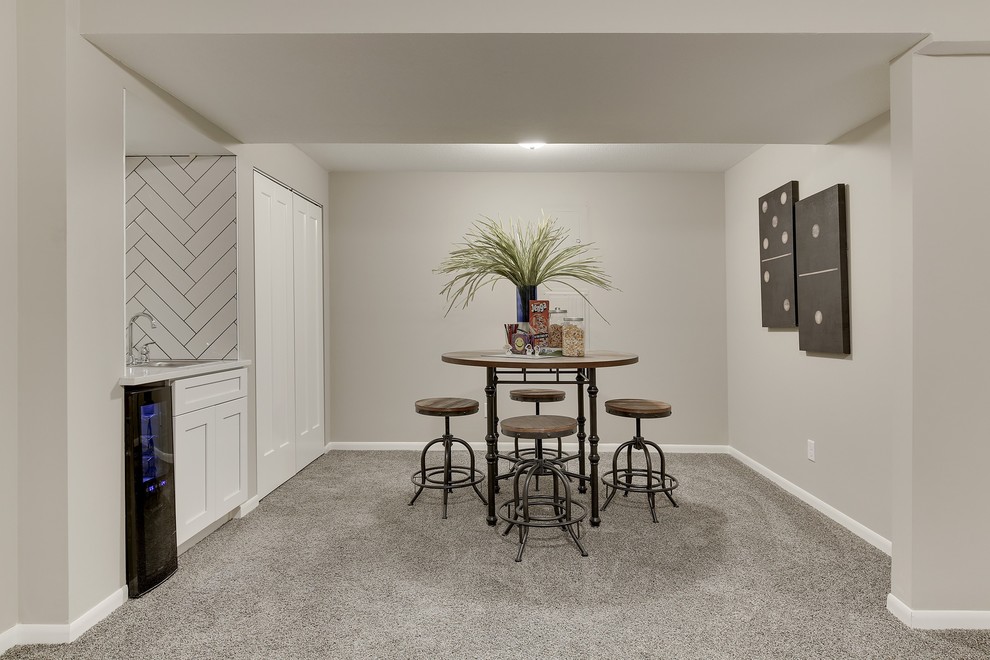 Photo of a mid-sized transitional fully buried basement in Minneapolis with grey walls, carpet and grey floor.