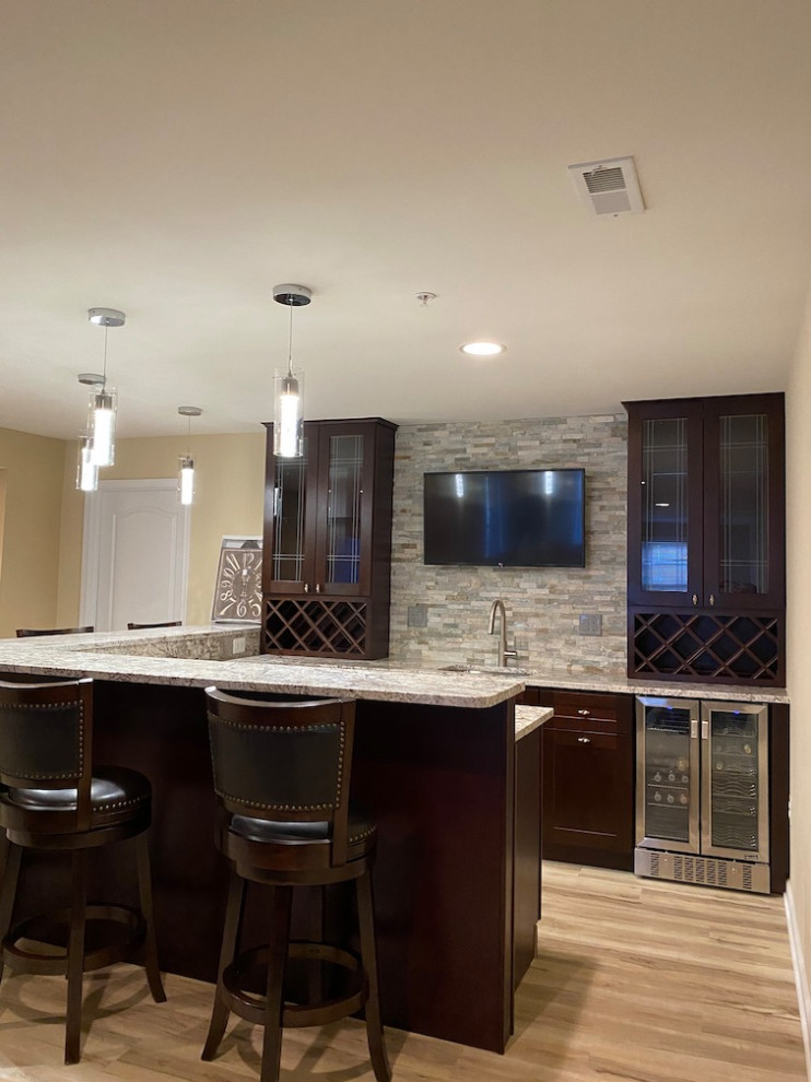 Cette photo montre un sous-sol tendance de taille moyenne avec un bar de salon, un mur marron, un sol en vinyl et un sol multicolore.