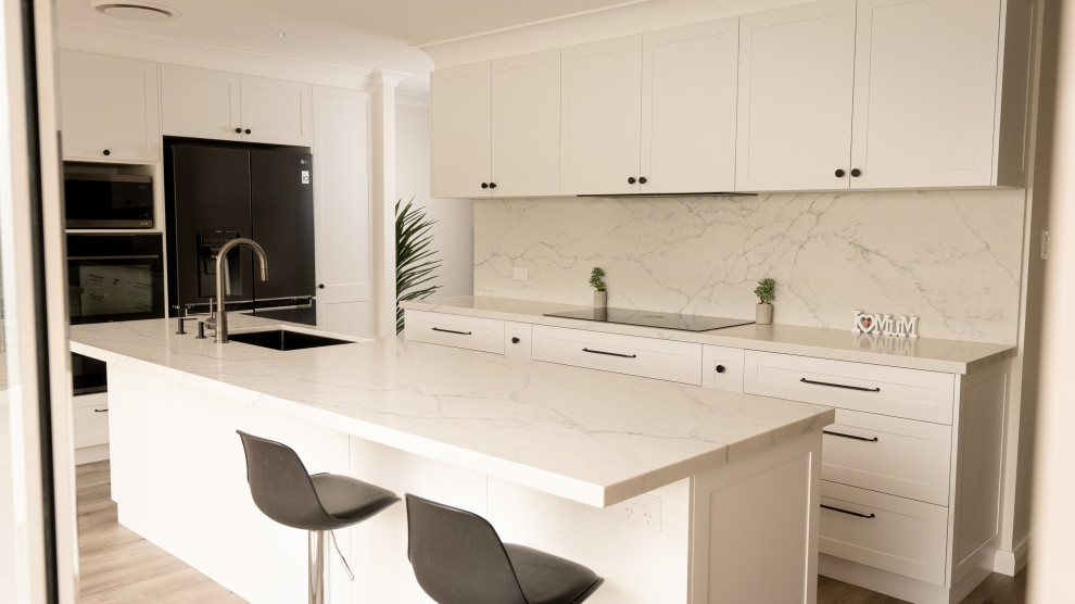 Design ideas for a large traditional l-shaped open plan kitchen in Sydney with an undermount sink, shaker cabinets, white cabinets, quartz benchtops, multi-coloured splashback, engineered quartz splashback, stainless steel appliances, medium hardwood floors, brown floor, multi-coloured benchtop and recessed.