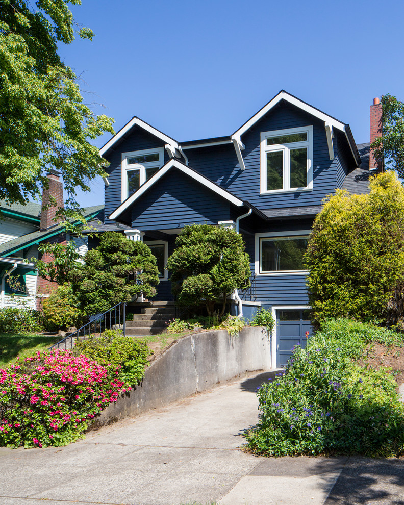 This is an example of a traditional two-storey blue house exterior in Portland with a gable roof and a shingle roof.