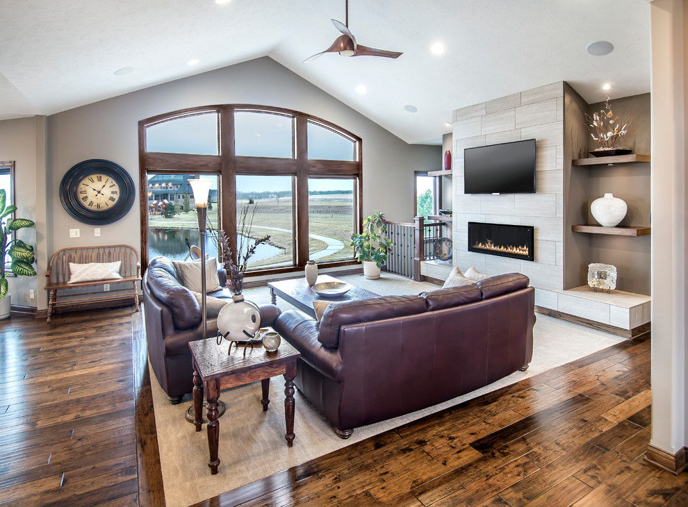 This is an example of an open concept living room in Other with beige walls, carpet, a ribbon fireplace, a tile fireplace surround and a wall-mounted tv.