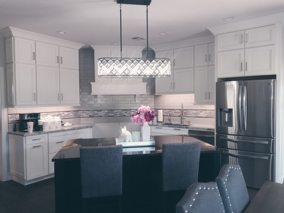 Mid-sized transitional eat-in kitchen photo with an undermount sink, recessed-panel cabinets, granite countertops, gray backsplash, subway tile backsplash, an island and black countertops