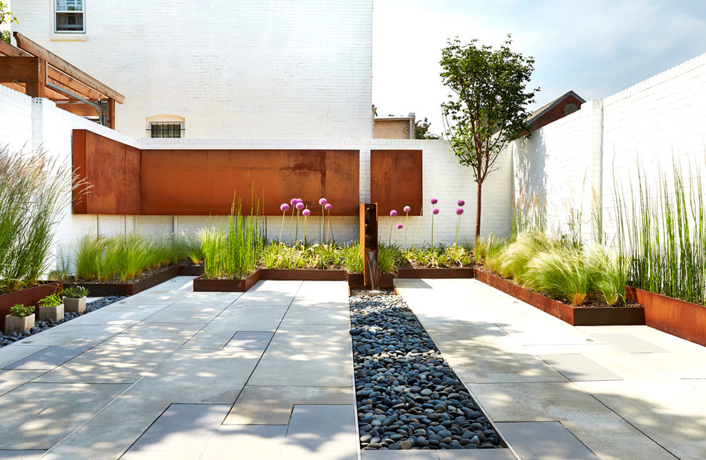 This is an example of a contemporary courtyard garden in DC Metro with a water feature.