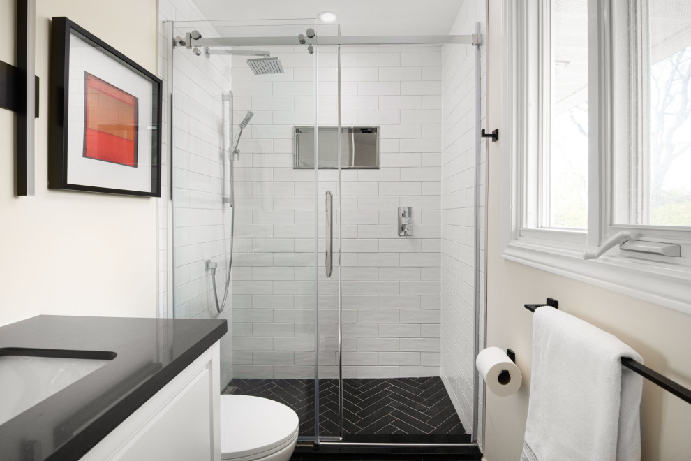 Photo of a small modern bathroom in Ottawa with white cabinets, an alcove tub, white tile, ceramic tile, white walls, ceramic floors, an integrated sink, quartzite benchtops, black floor, a sliding shower screen, black benchtops and a single vanity.