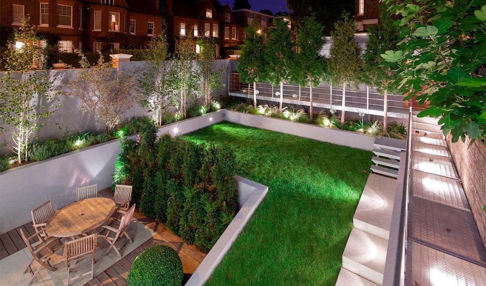 Design ideas for a mid-sized contemporary backyard formal garden in London with with privacy feature.