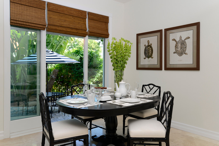 Photo of a mid-sized tropical separate dining room in Miami with white walls and travertine floors.