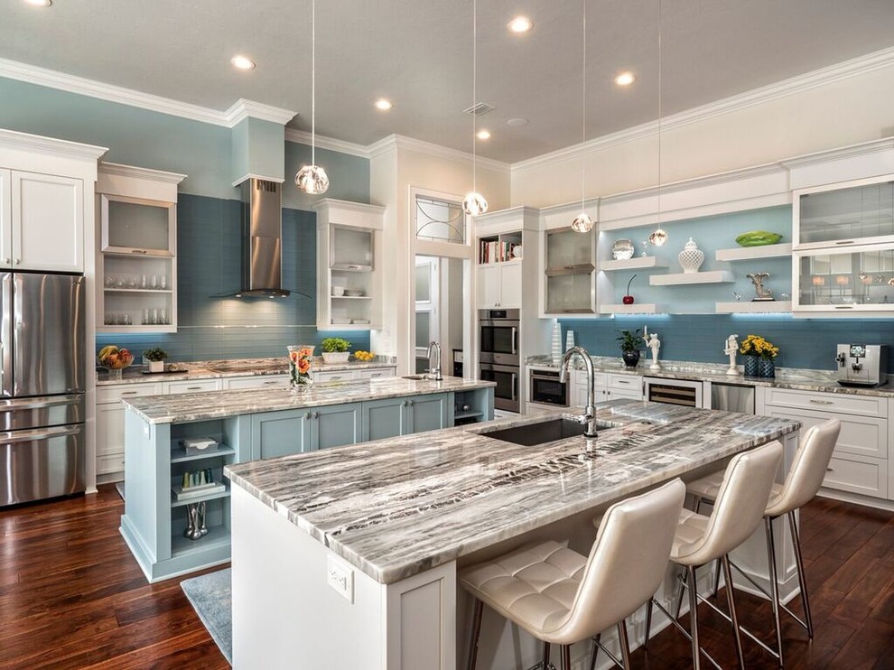Photo of a large transitional l-shaped eat-in kitchen in Miami with an undermount sink, shaker cabinets, white cabinets, marble benchtops, blue splashback, subway tile splashback, stainless steel appliances, medium hardwood floors and multiple islands.